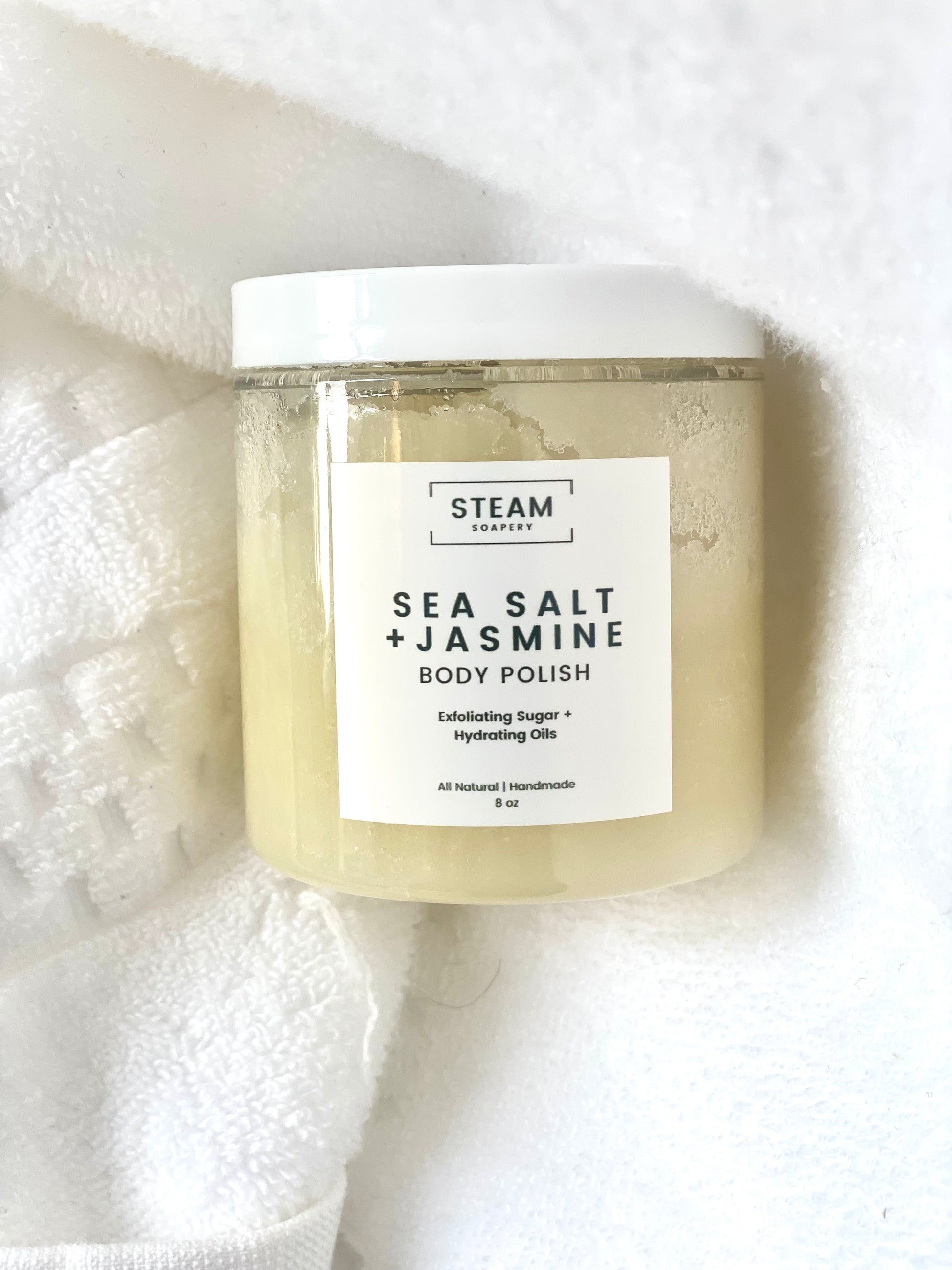 Jar of Sea Salt + Jasmine body polish on a white towel