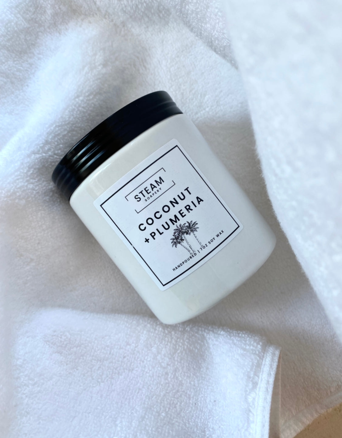 Coconut Plumeria Candle on a White Towel